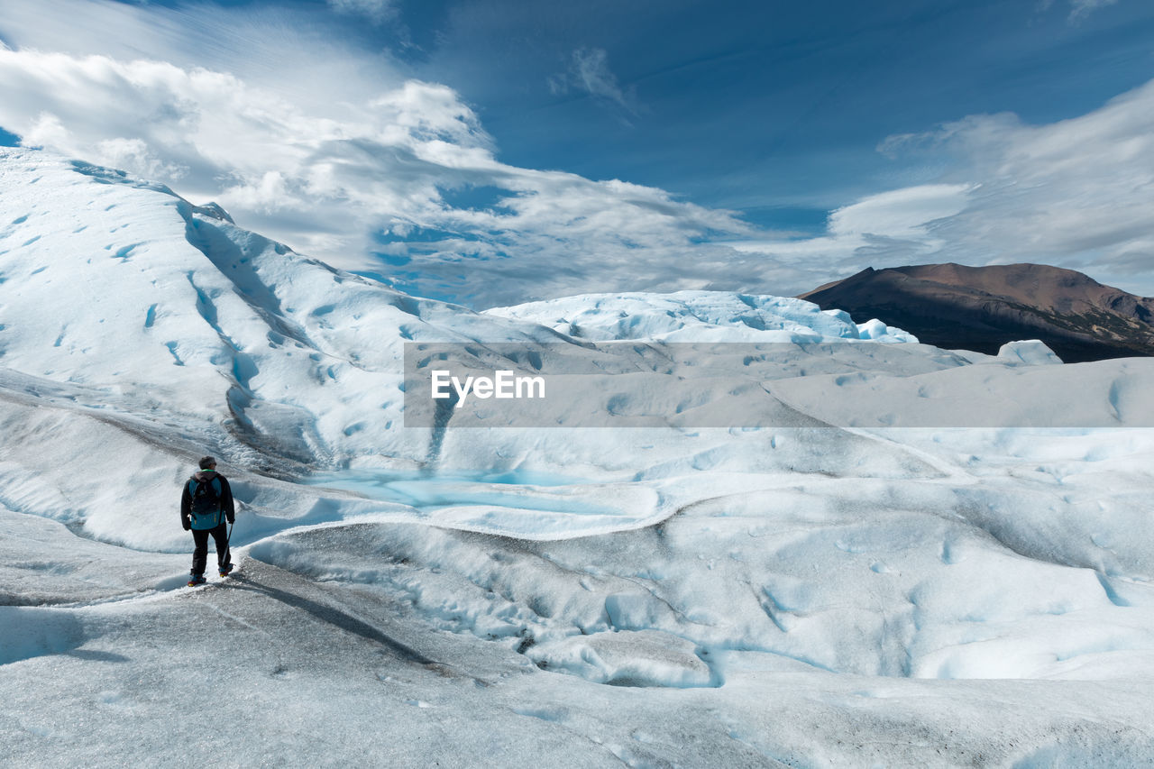 FULL LENGTH OF PERSON STANDING ON SNOWCAPPED MOUNTAIN