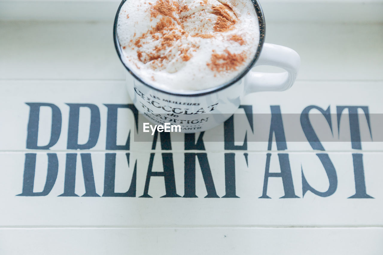 HIGH ANGLE VIEW OF COFFEE WITH TEXT ON TABLE