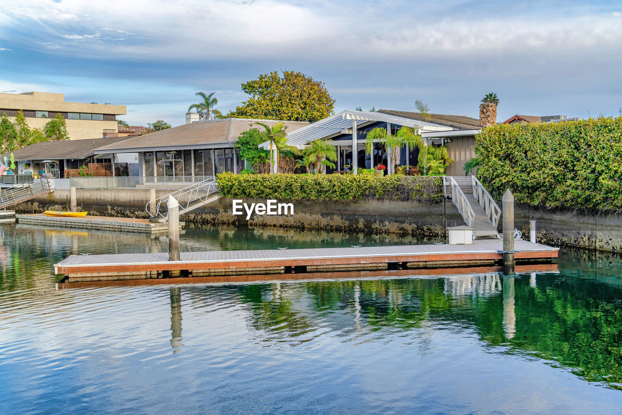 VIEW OF SWIMMING POOL BY LAKE AGAINST BUILDING