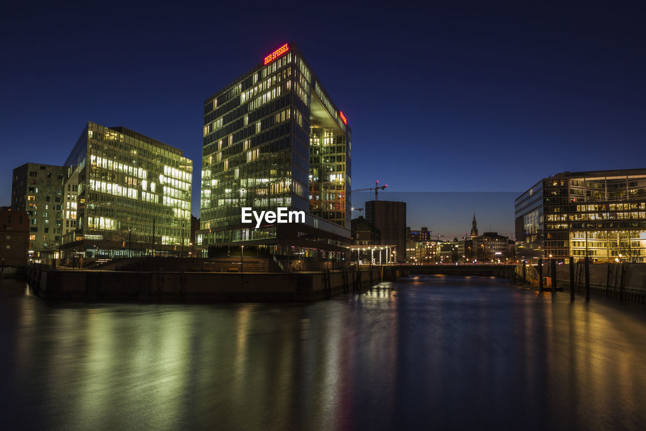 VIEW OF ILLUMINATED BUILDINGS AGAINST CLEAR SKY