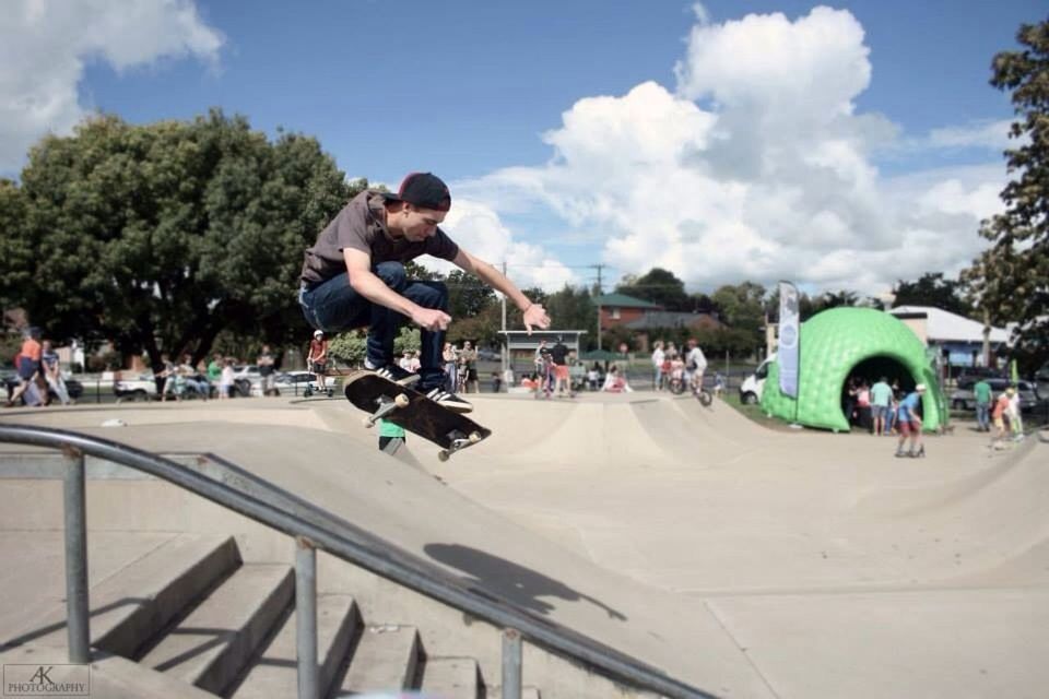 Young skateboarder performing tricks at skatepark