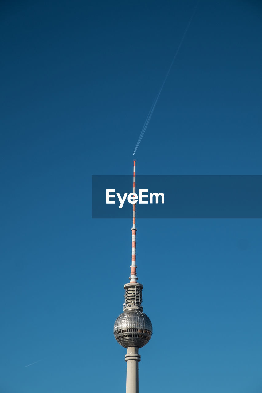 Low angle view of fernsehturm tower against clear blue sky