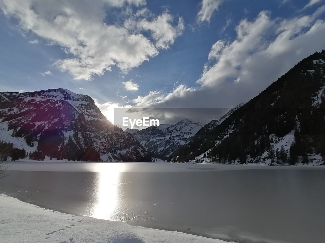 Scenic view of snowcapped mountains against sky at lake