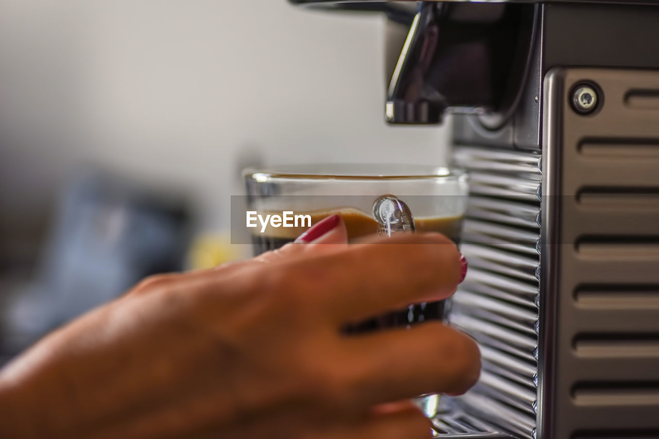 CLOSE-UP OF HUMAN HAND HOLDING CUP