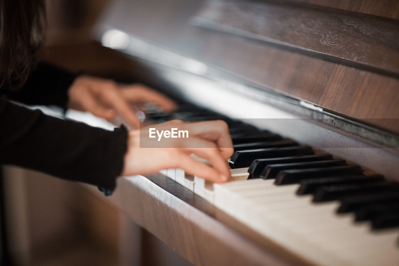 MIDSECTION OF MAN PLAYING PIANO AT MUSIC CONCERT