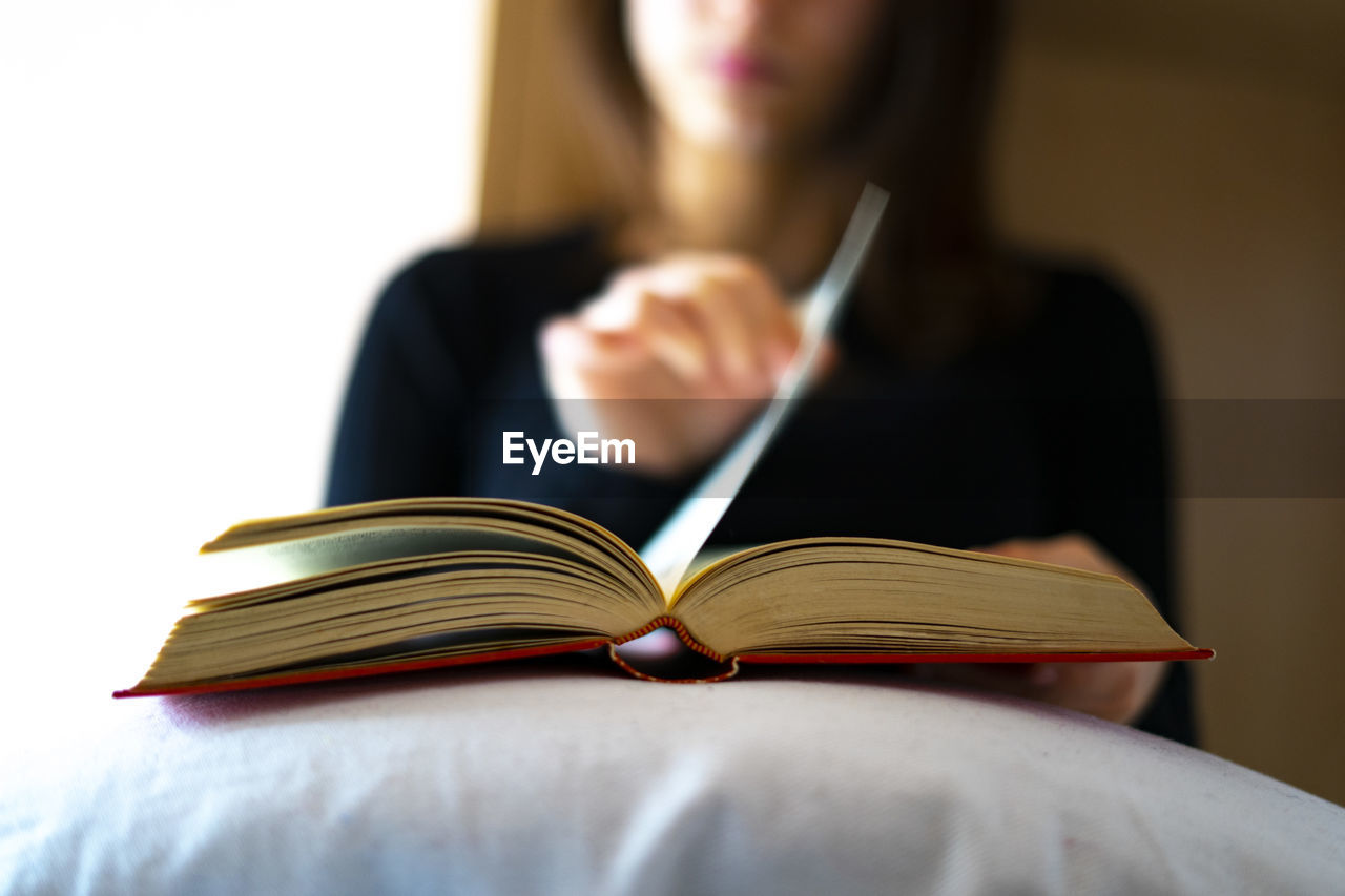 Woman turning the page of a book.