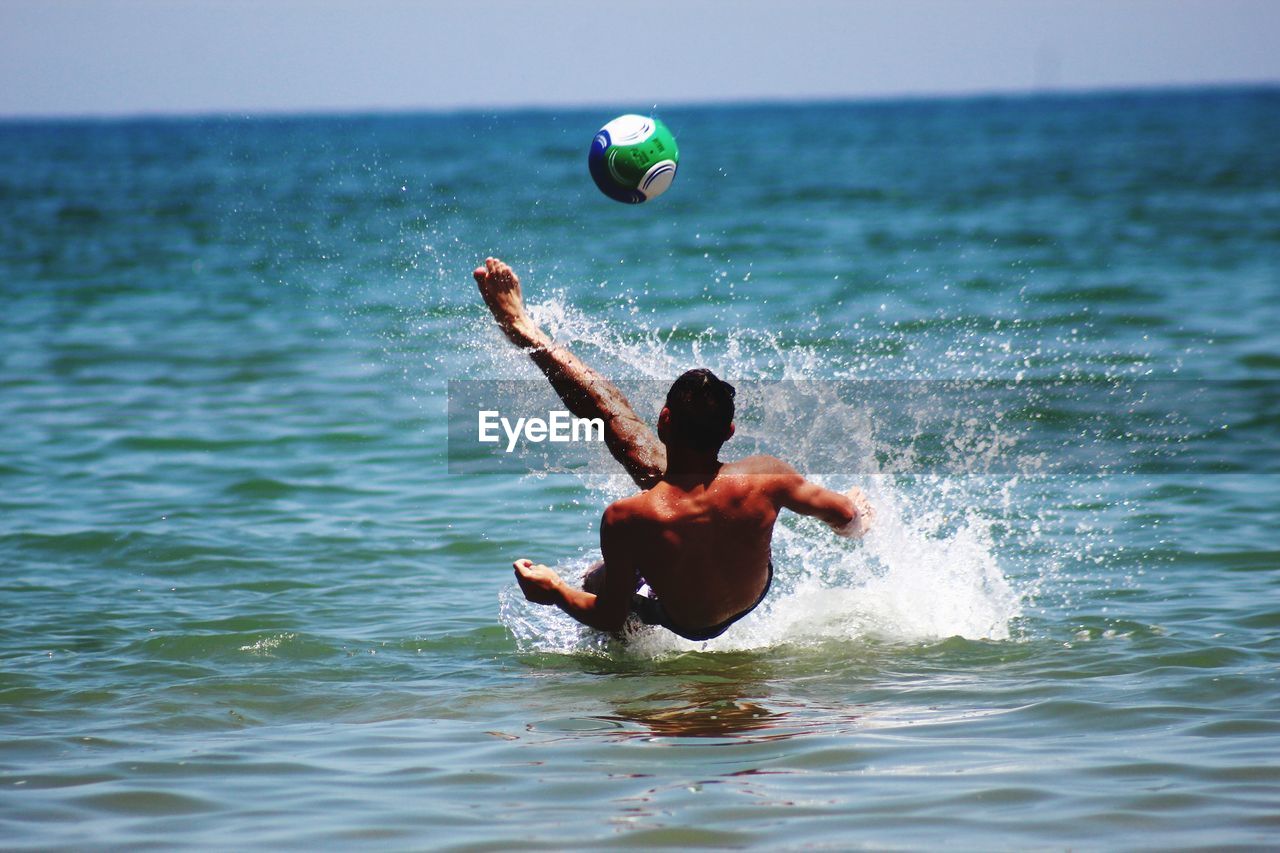 Rear view of shirtless man in sea