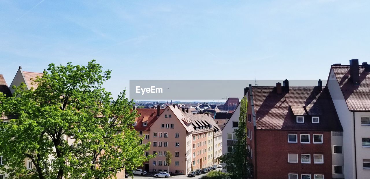 Buildings in town against blue sky