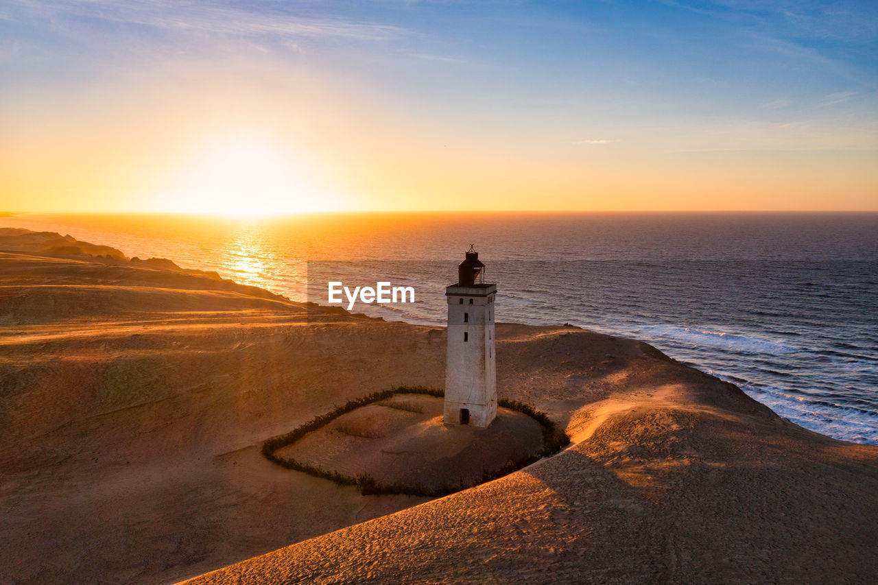 Rubjerg knude fyr lighthouse in sunset from drone
