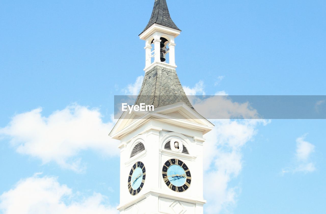 LOW ANGLE VIEW OF CLOCK TOWER AMIDST BUILDINGS AGAINST SKY