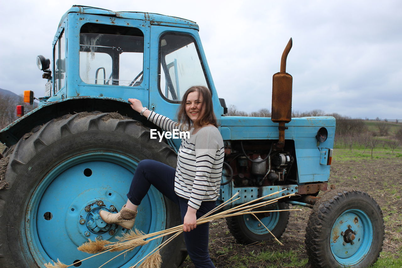 Countryside. a girl in a field and a big tractor. ingathering. high quality photo