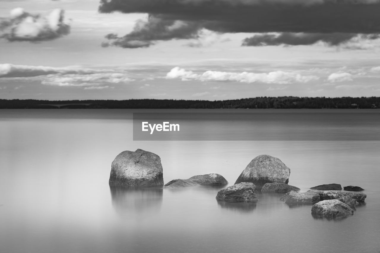 Rocks in sea against sky