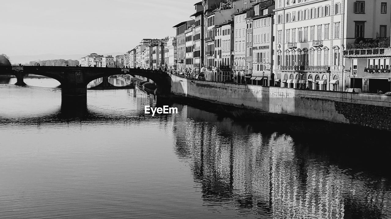 BRIDGE OVER RIVER BY BUILDINGS AGAINST SKY IN CITY