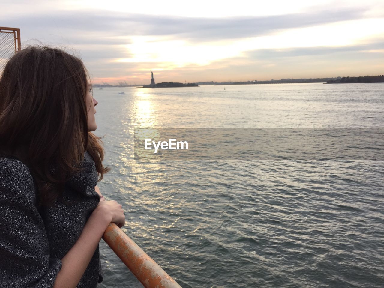 Woman traveling through staten island ferry in hudson river against sky