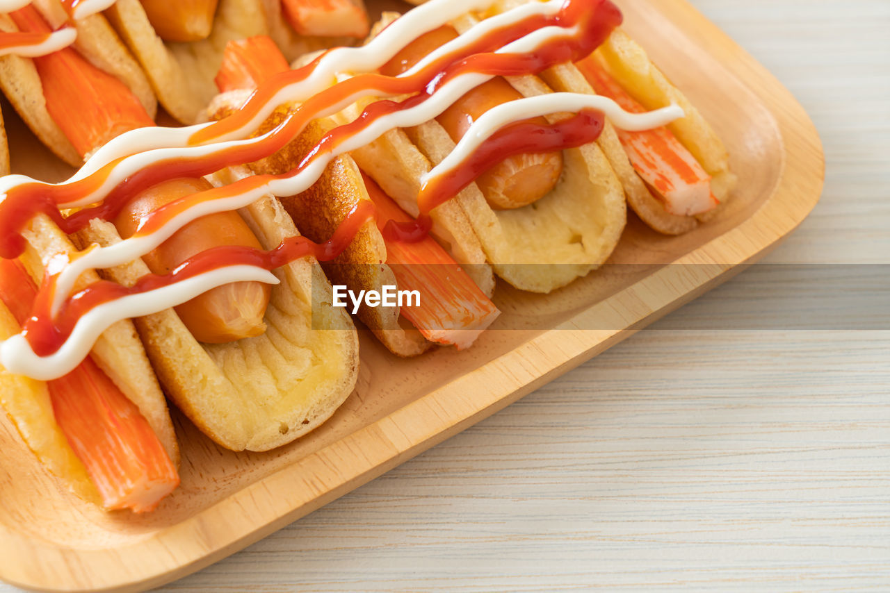 HIGH ANGLE VIEW OF HOT DOG AND VEGETABLES ON TABLE