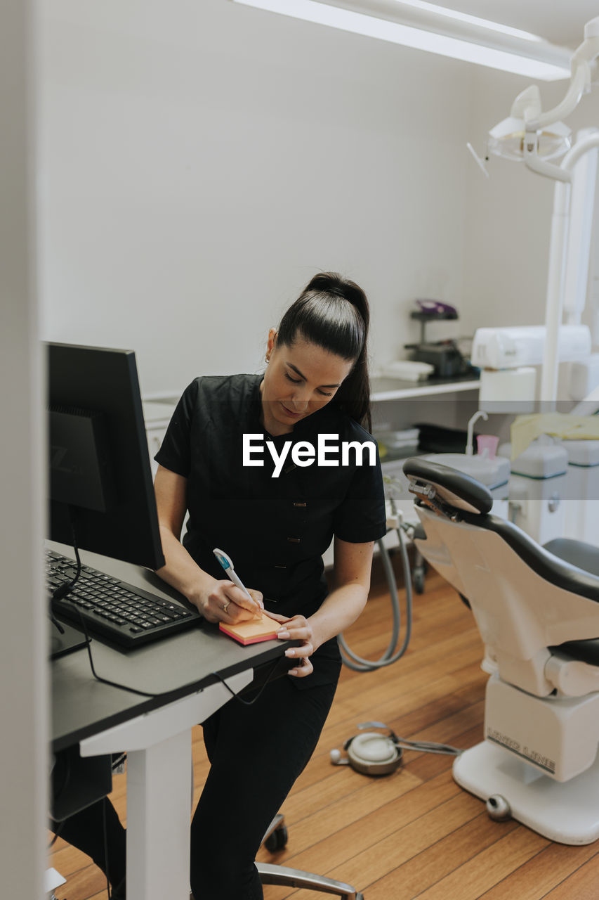 Female dentist using computer in office