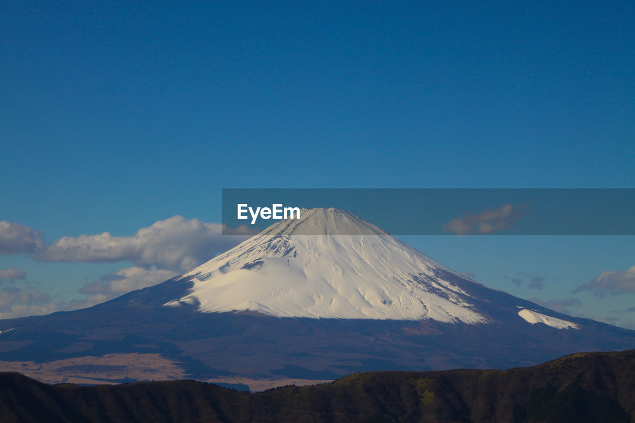 Snow covered mountain peak against blue sky