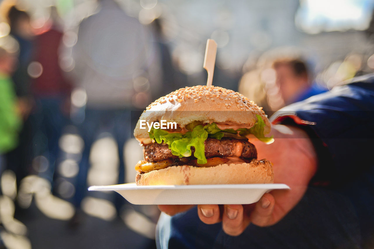 Close-up of man holding burger