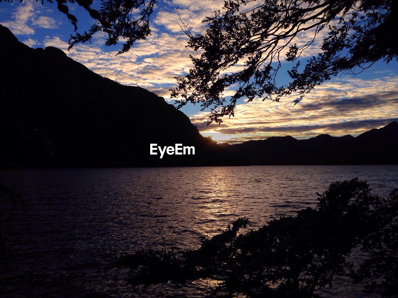 SCENIC VIEW OF LAKE BY SILHOUETTE MOUNTAIN AGAINST SKY