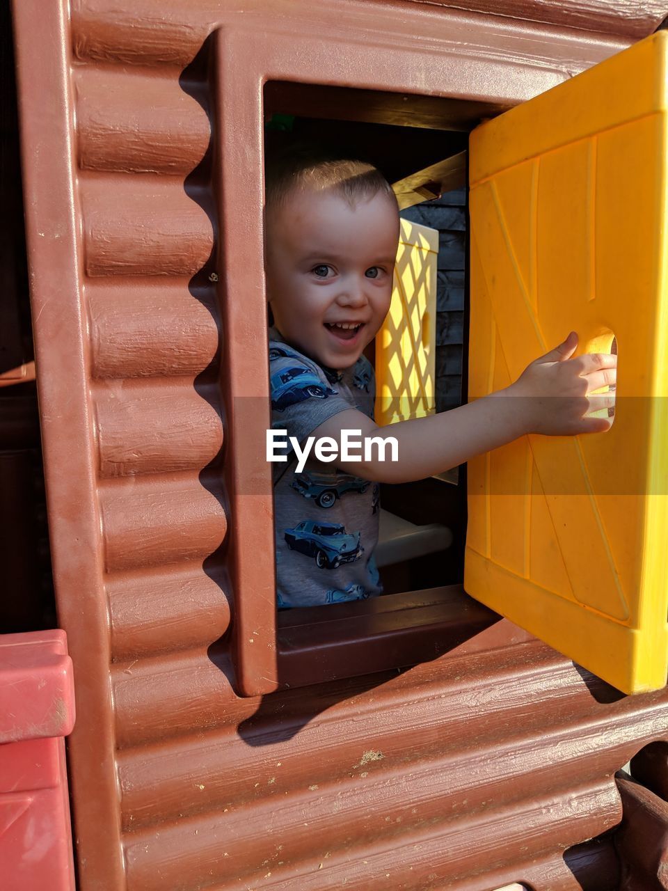 Portrait of cute happy boy seen through window