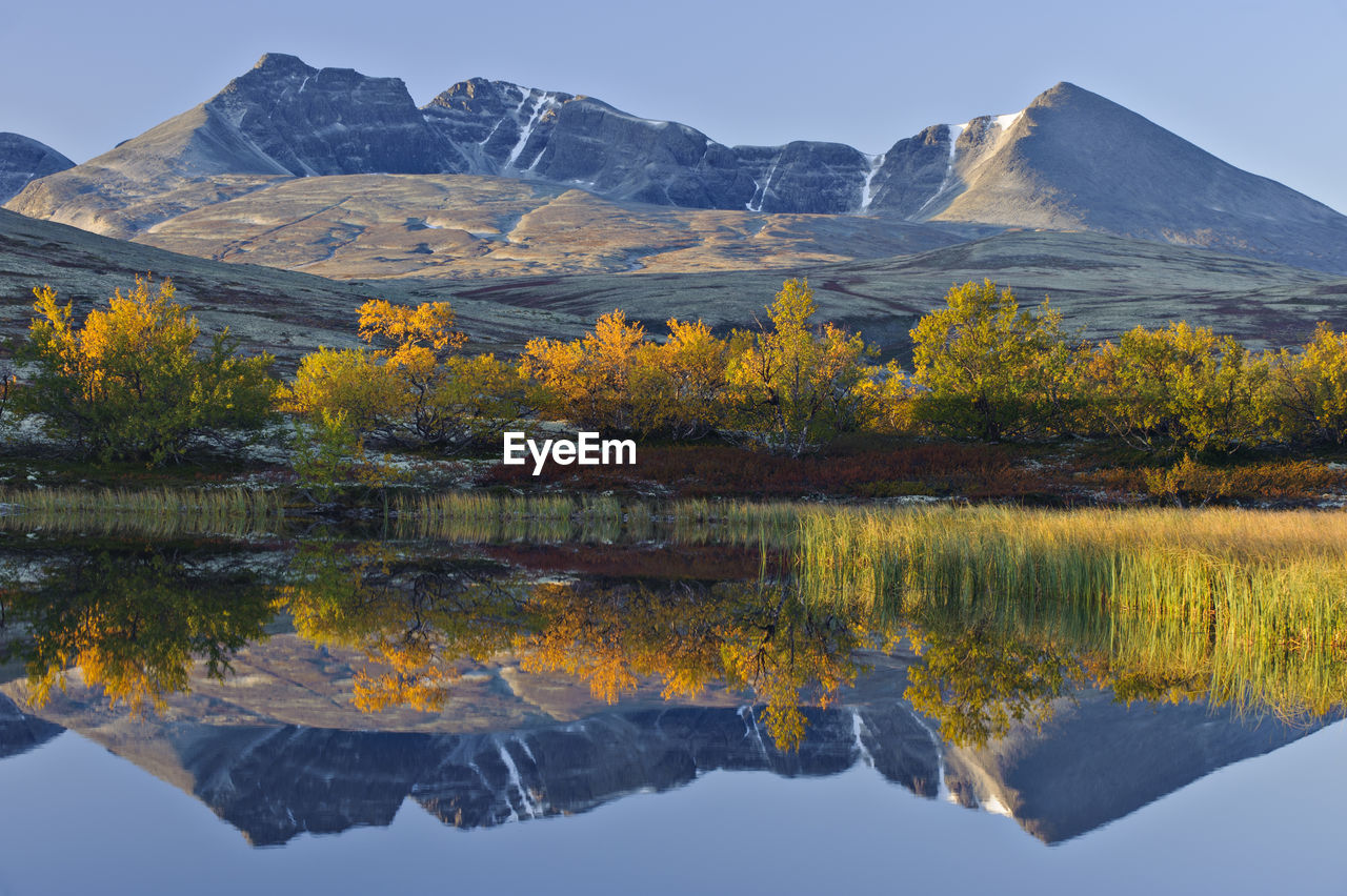 Reflection of rondslottet mountain. rondane national park, norway, europe