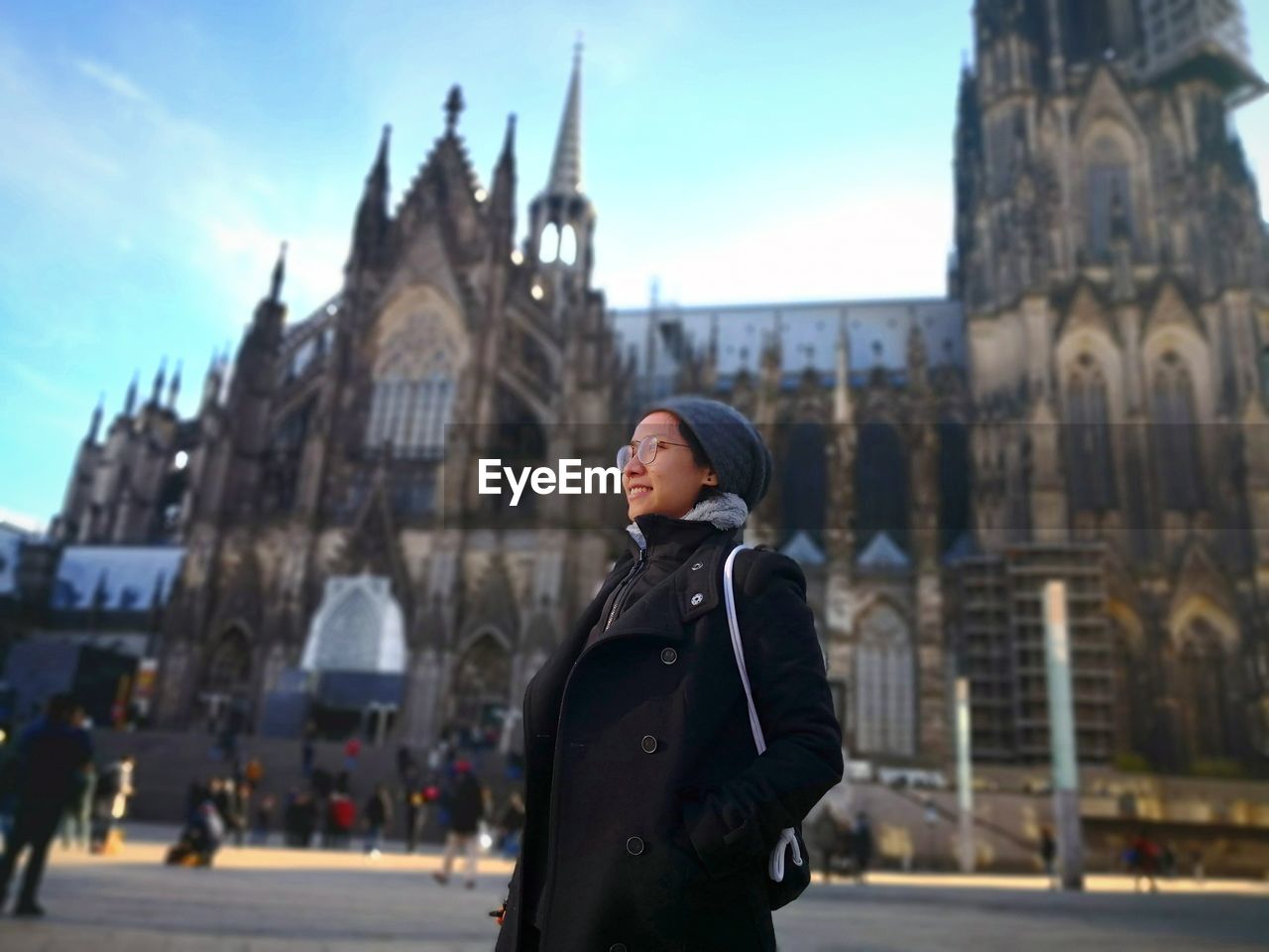 Woman standing outside cologne cathedral on street in city