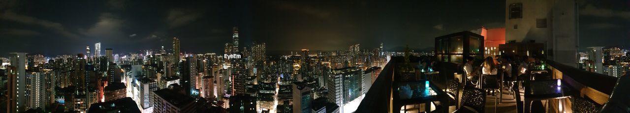 Panoramic shot of illuminated buildings against sky at night