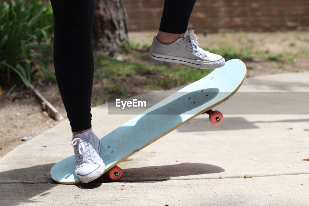 Low section of woman skateboarding at park