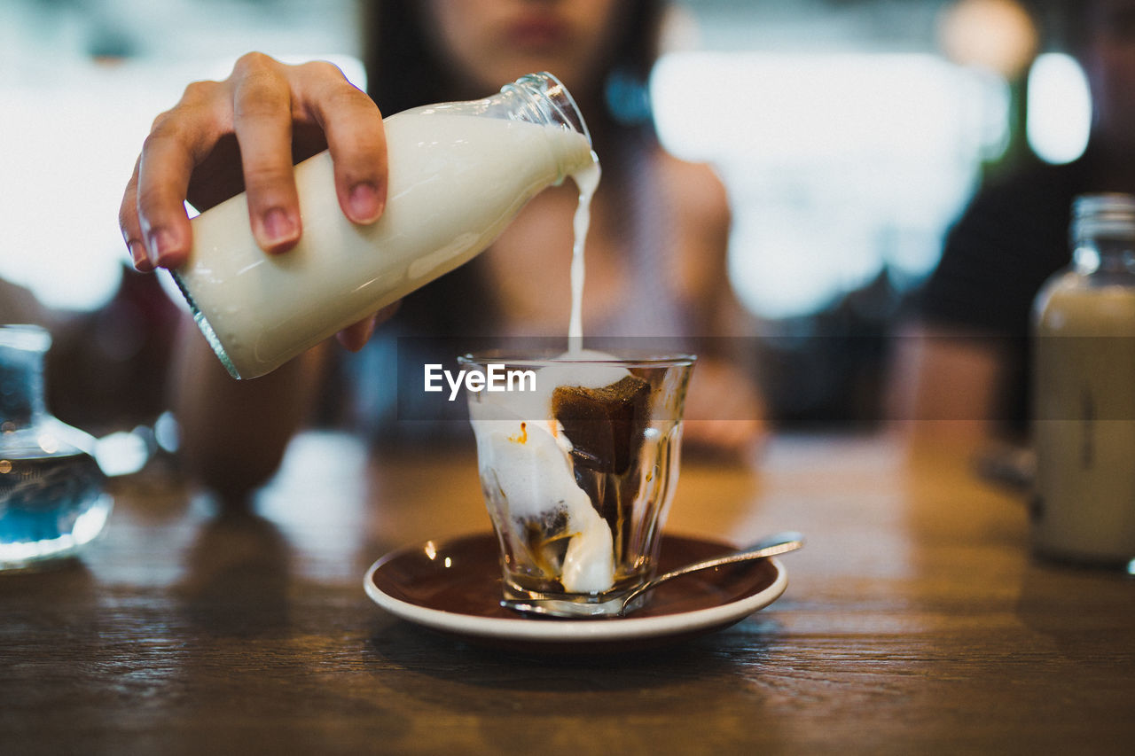 Midsection of woman preparing coffee at table