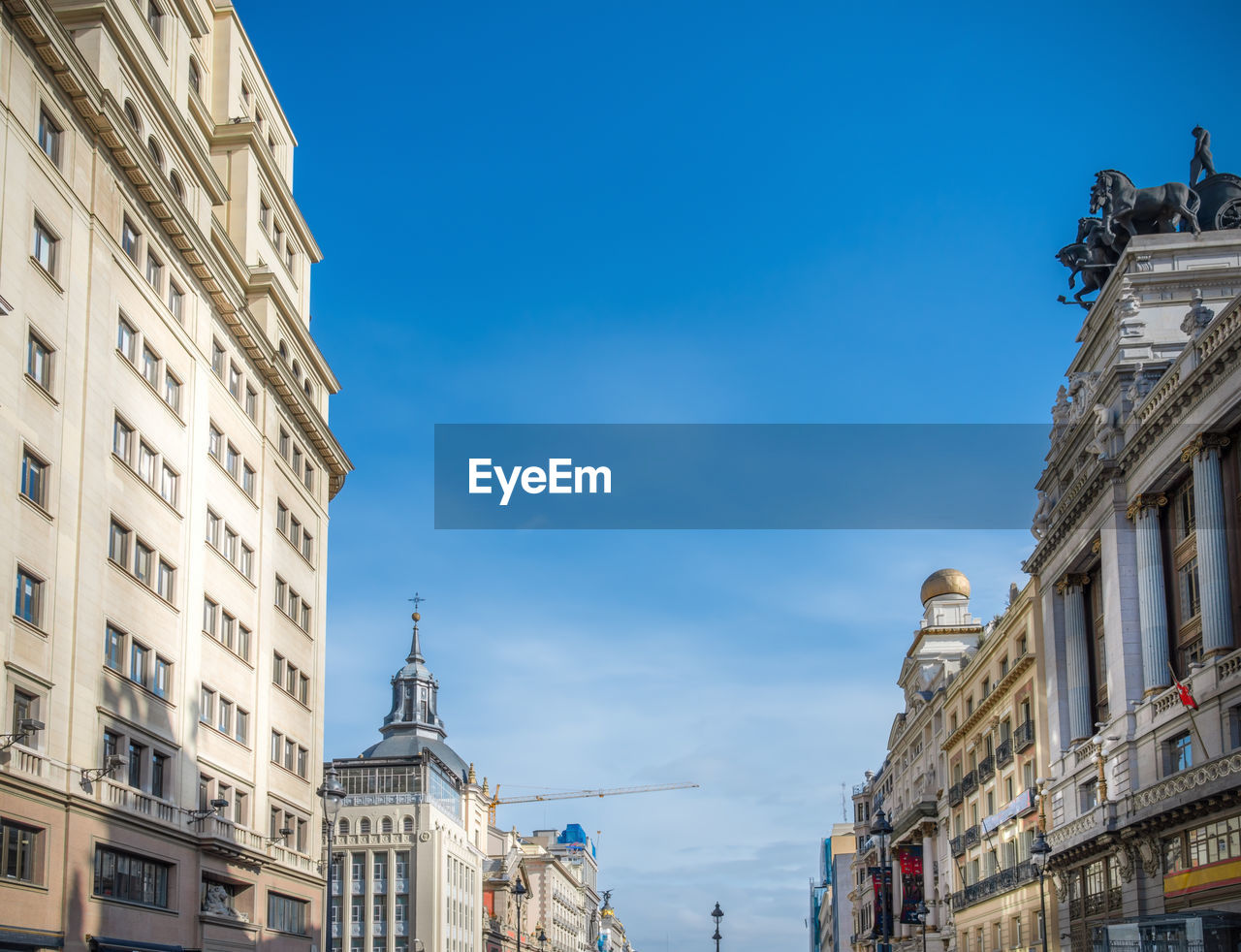 LOW ANGLE VIEW OF BUILDINGS AGAINST BLUE SKY