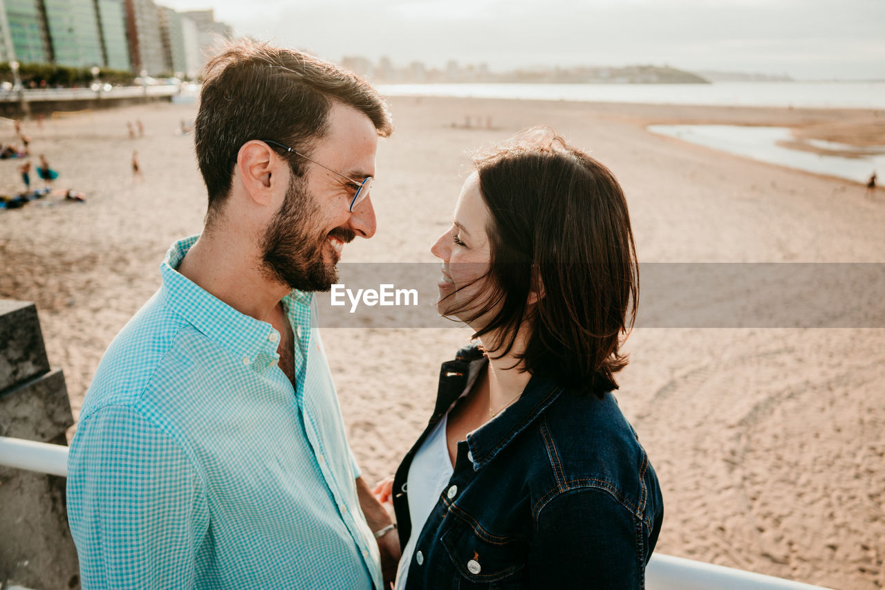 Couple embracing while standing on beach