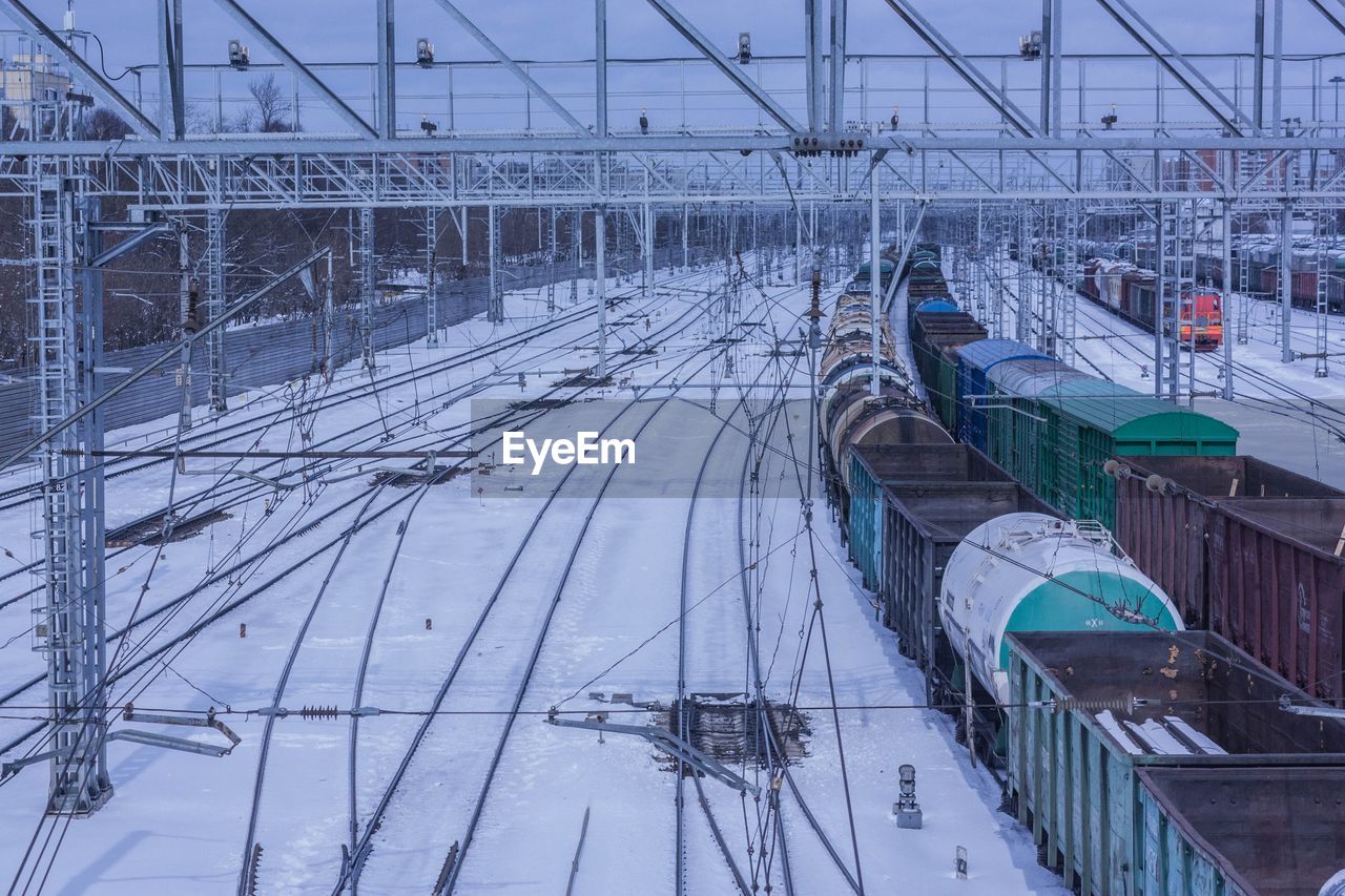 transportation, transport, winter, snow, cold temperature, architecture, built structure, train, vehicle, mode of transportation, rail transportation, nature, high angle view, day, travel, railroad track, no people, track, outdoors, cable, business finance and industry, city, building exterior