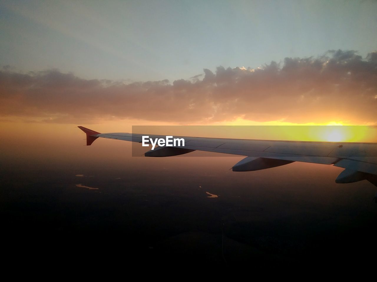 Silhouette airplane wing against sky during sunset