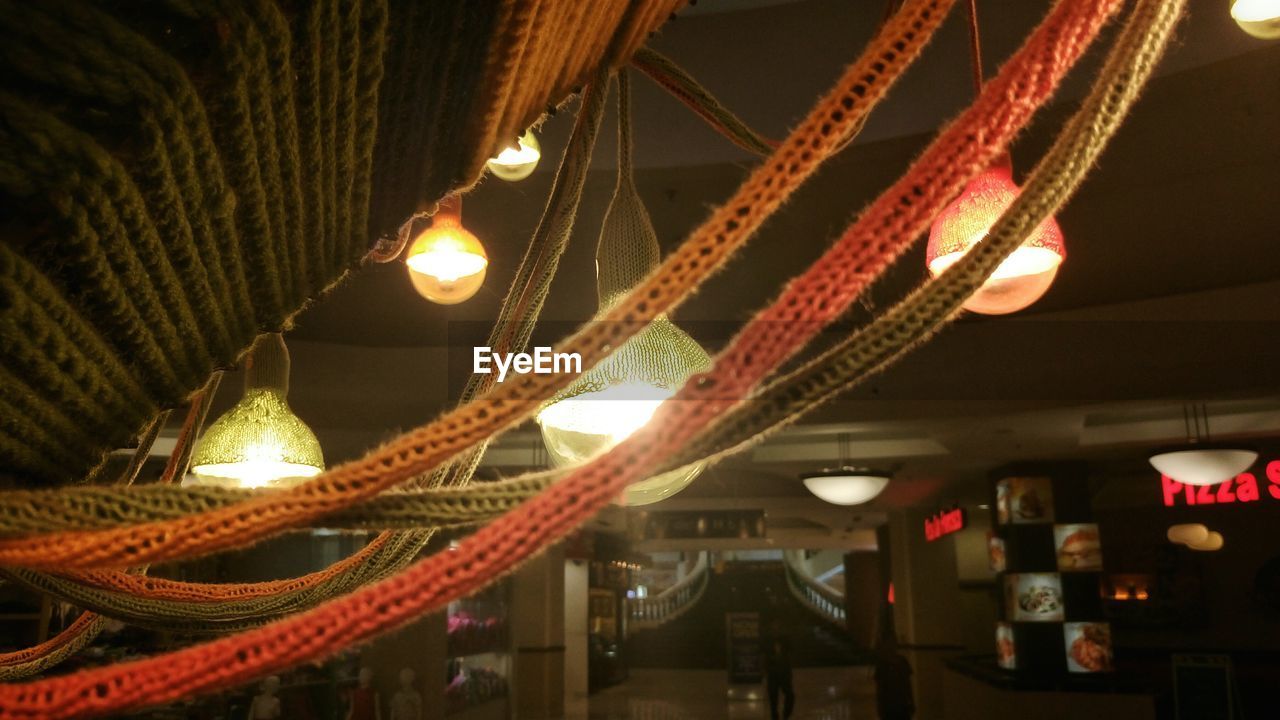 LOW ANGLE VIEW OF ILLUMINATED LIGHTS AT NIGHT