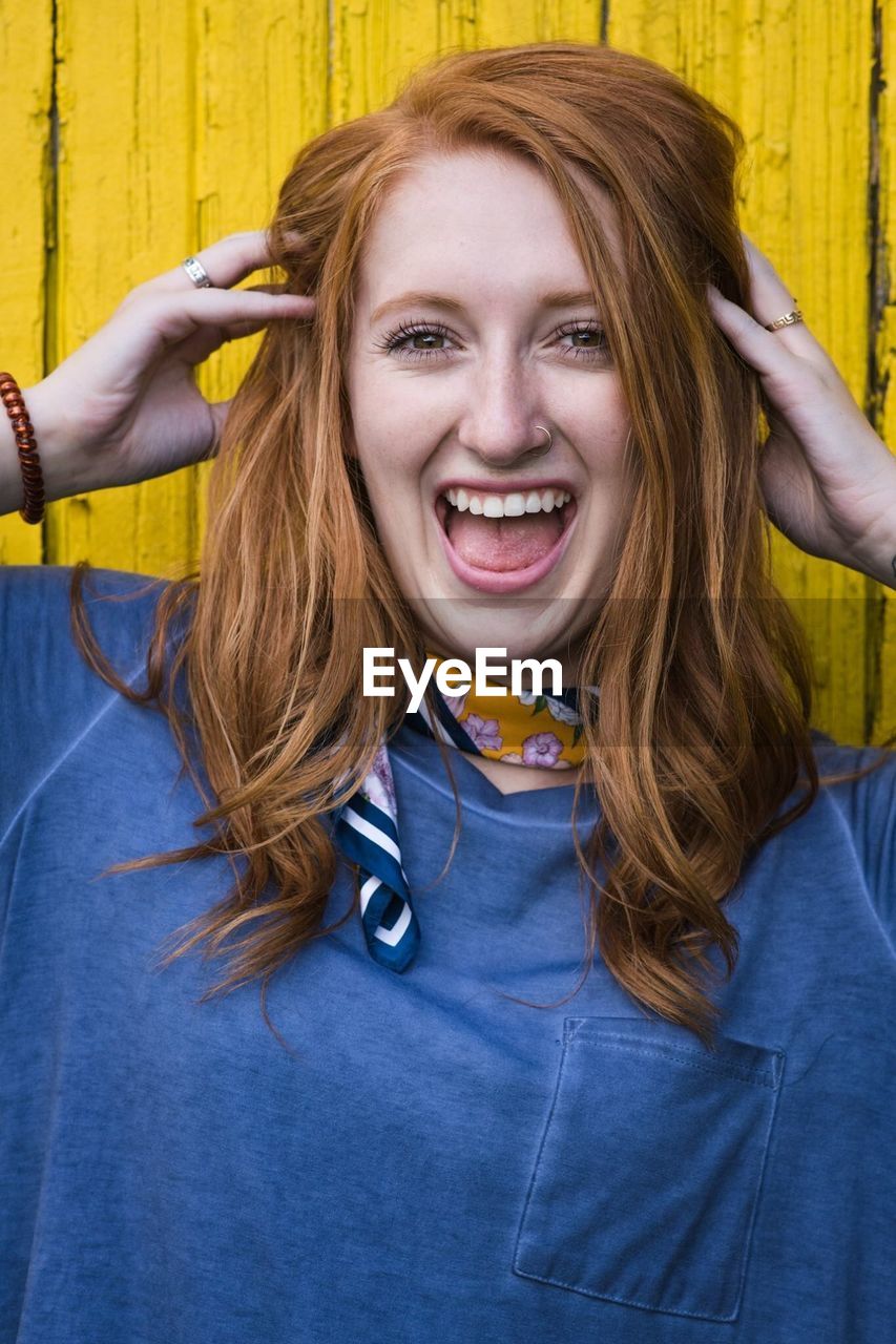 Portrait of happy young woman screaming outdoors