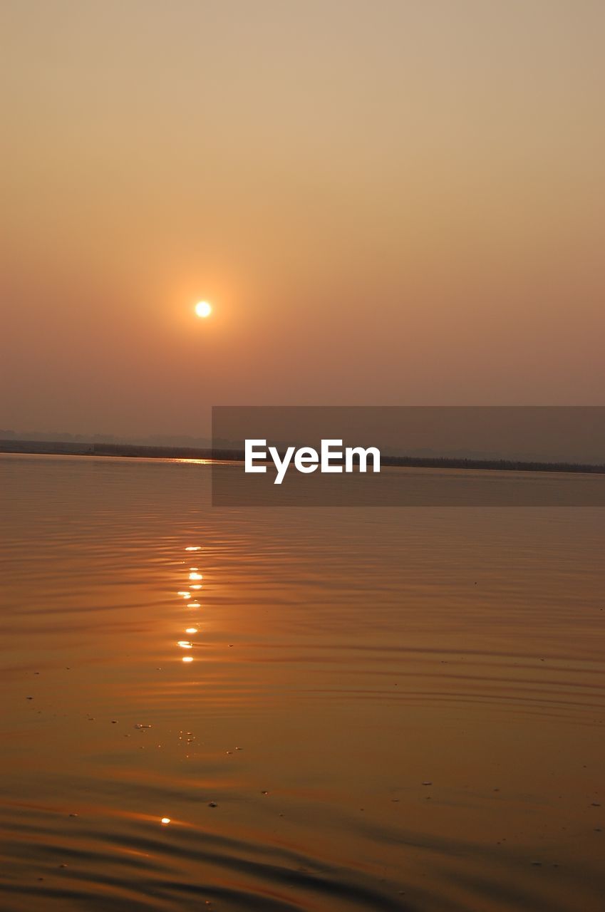 SCENIC VIEW OF BEACH AGAINST SKY DURING SUNSET