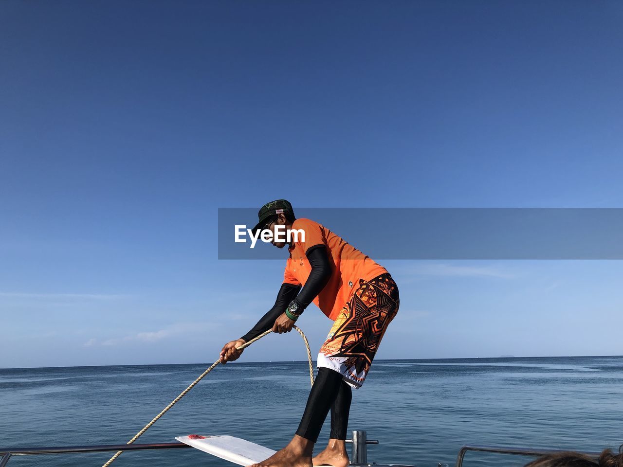 MAN IN SEA AGAINST SKY