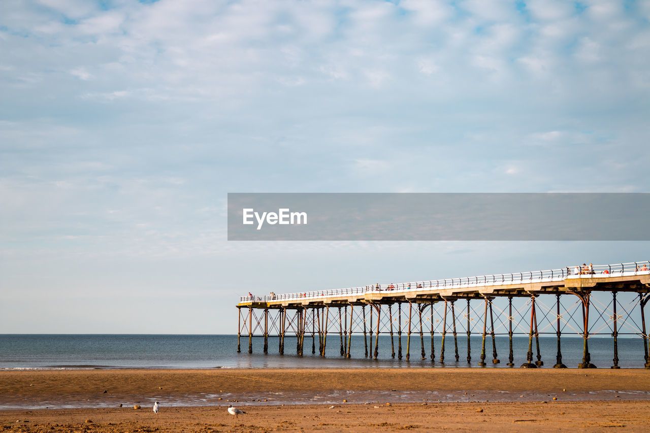 PIER ON SEA SHORE AGAINST SKY