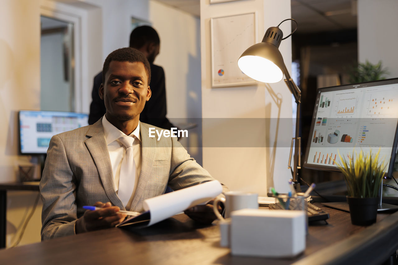 side view of businessman using laptop on table in office