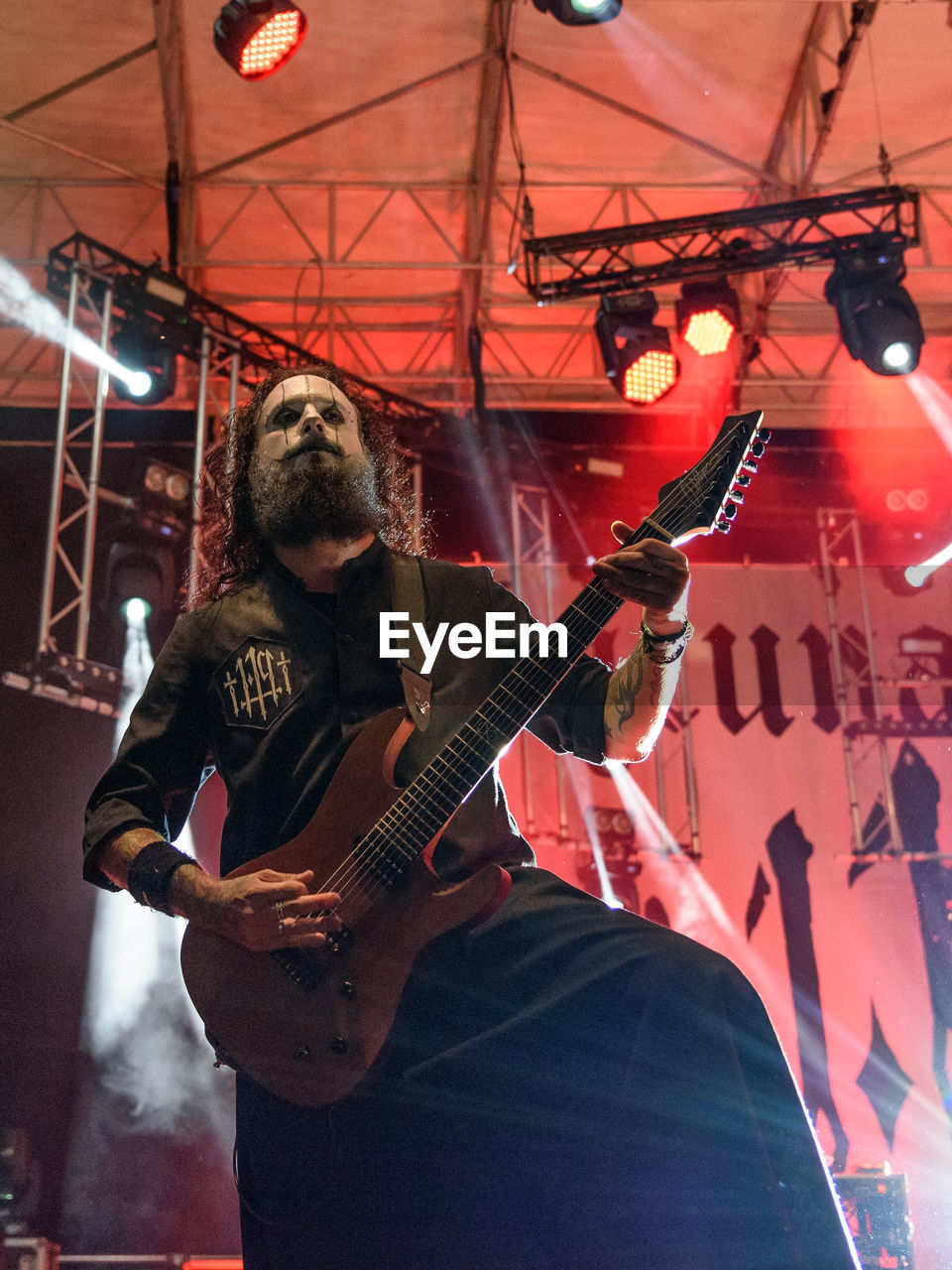 MAN PLAYING GUITAR IN ILLUMINATED STAGE