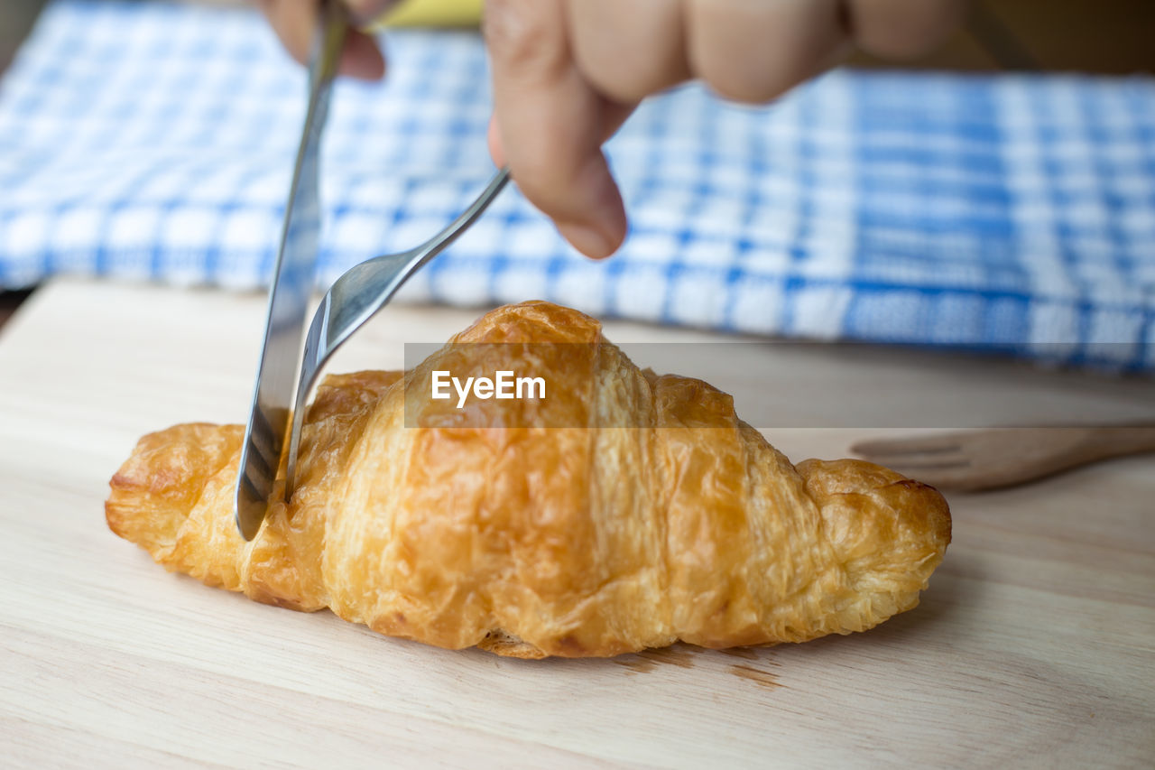 Freashly baked tasty croissants on wooden background.