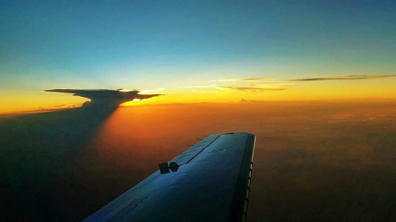 CROPPED IMAGE OF AIRPLANE FLYING OVER CLOUDS