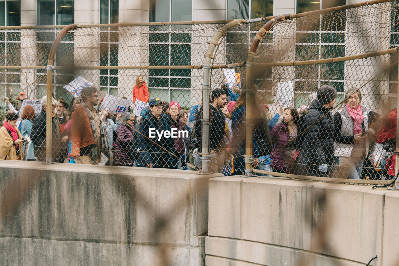 GROUP OF PEOPLE ON FENCE