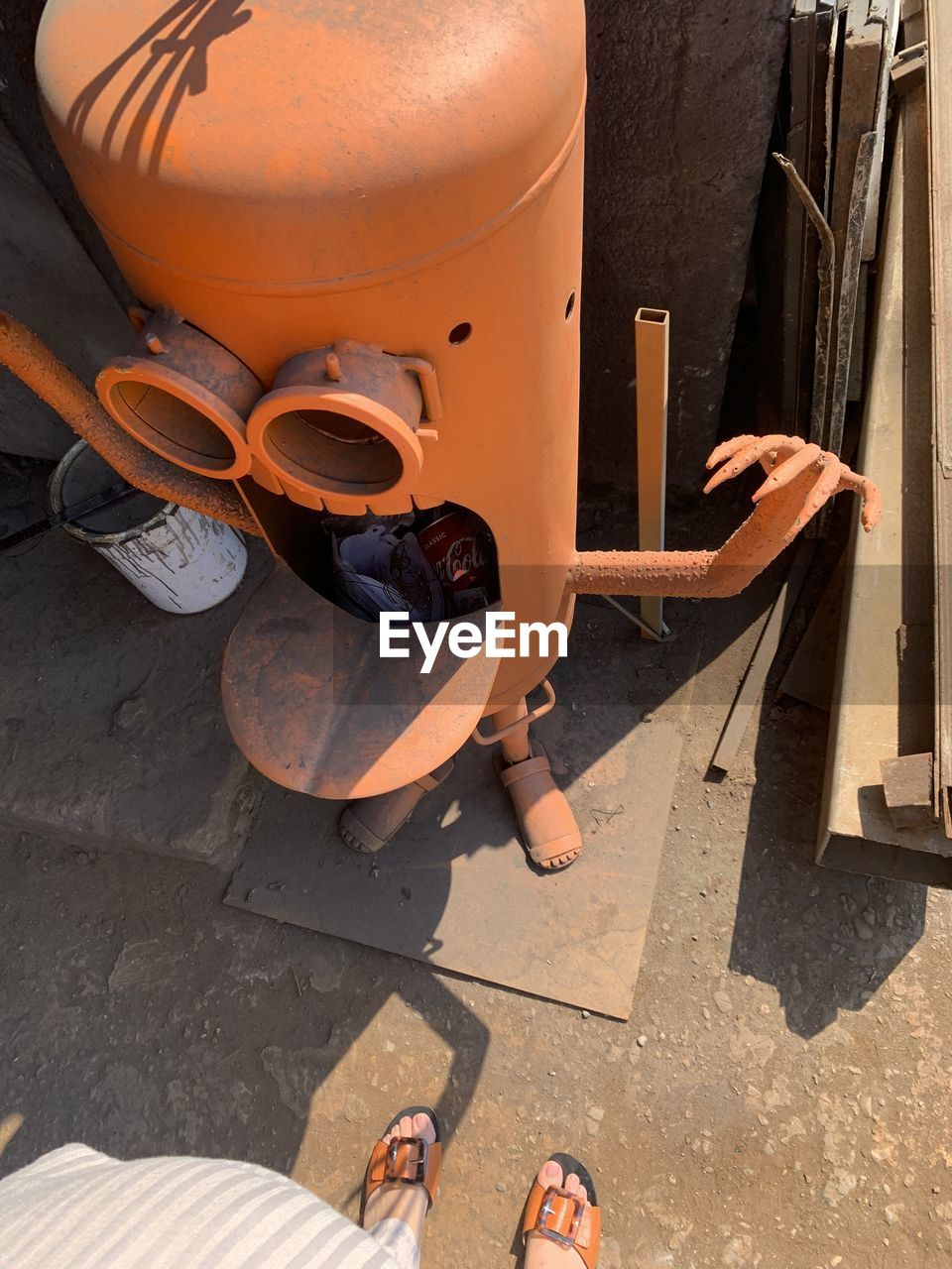 Low section of woman standing by garbage bin