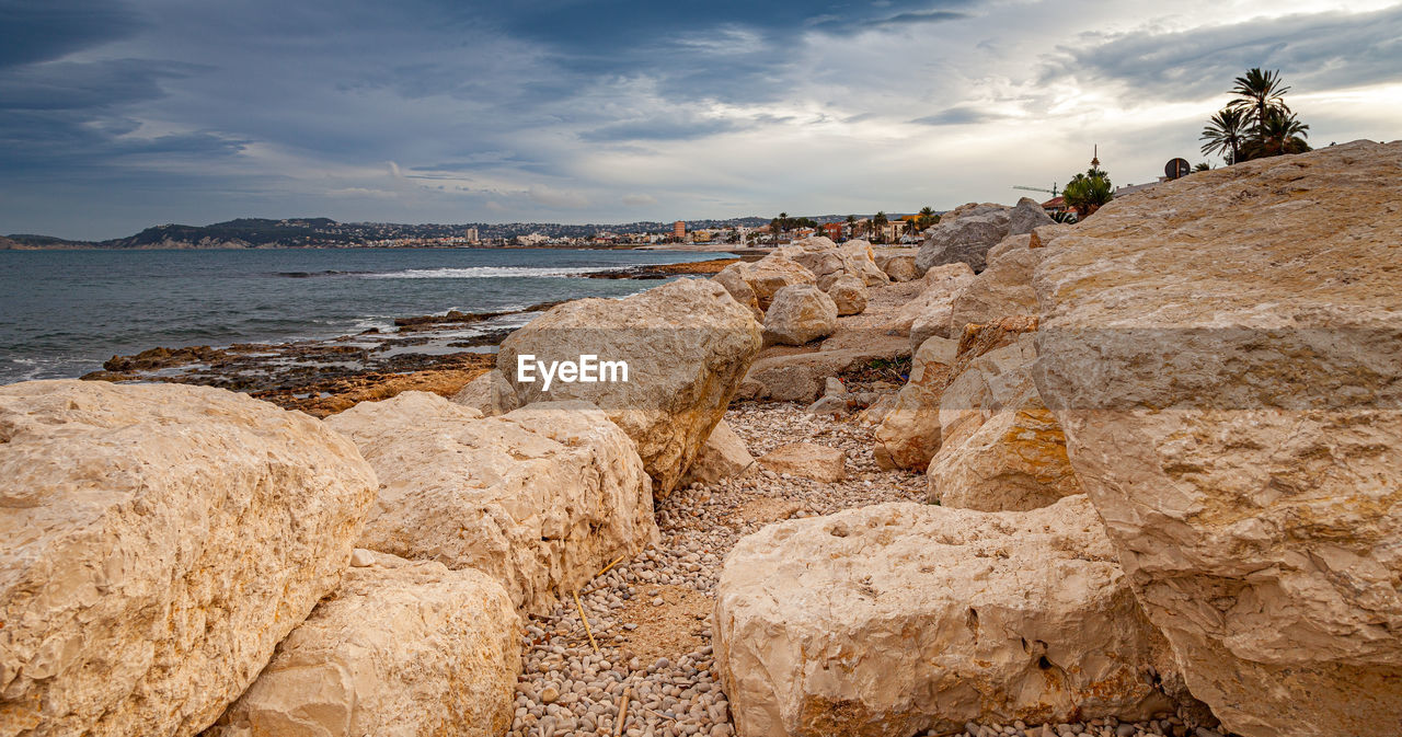 Panoramic view of rocks on beach against sky