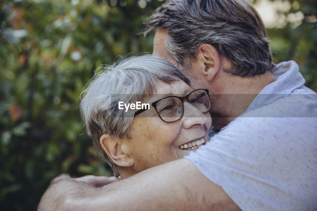 Adult son embracing his mother in the garden