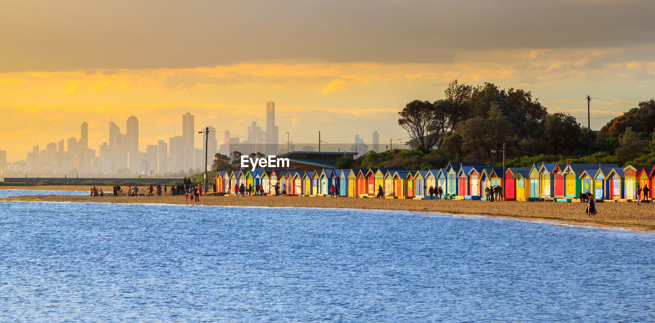 Scenic view of sea against buildings during sunset