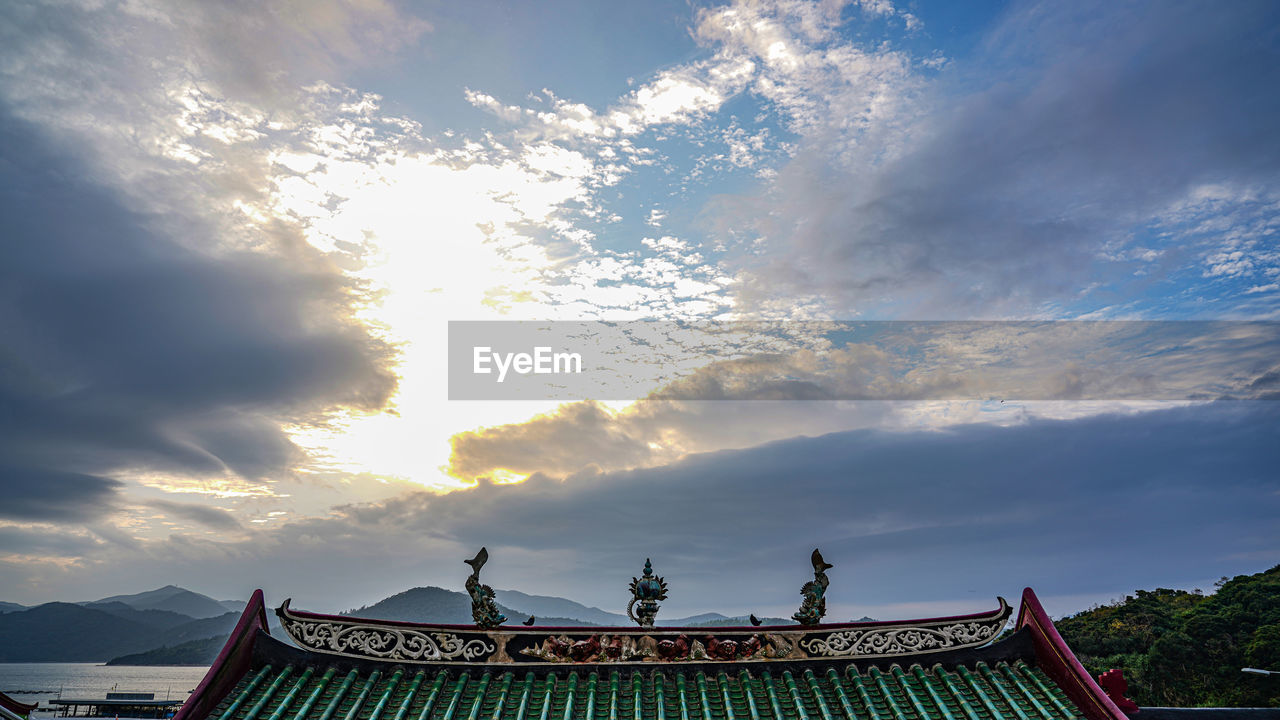 LOW ANGLE VIEW OF ROOF AND BUILDING AGAINST SKY