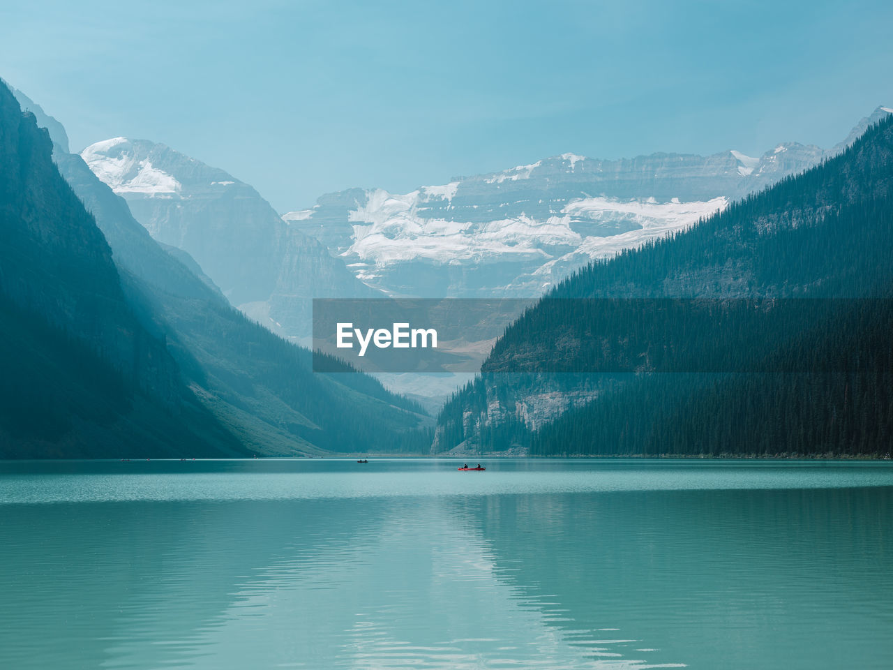 Scenic view of lake and snowcapped mountains against clear sky