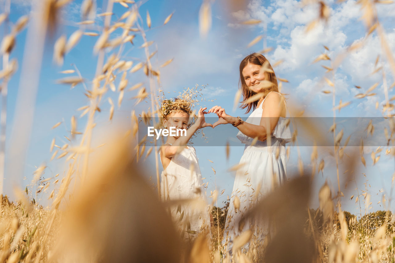 YOUNG WOMAN STANDING IN A FIELD